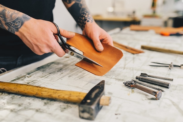 leather craft tools on a wooden background. leather craftmans work desk 