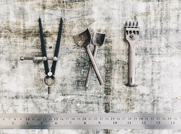 Leather craft tools on a work table background. Leather craftmans work desk