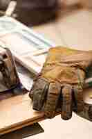 Foto gratuita guanti in pelle su tavola di lavoro artigianale