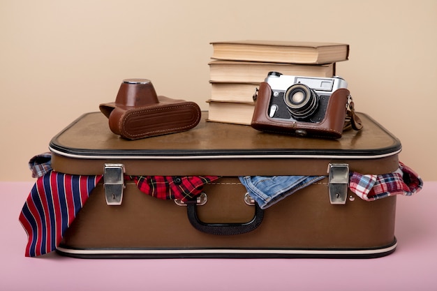Leather suitcase packed with camera and books