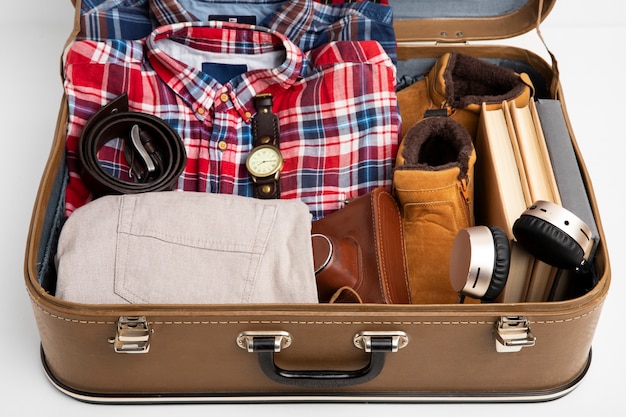 Leather suitcase packed with shoes and travel paraphernalia