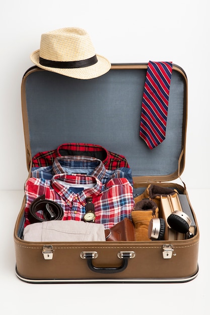 Leather suitcase packed with shoes and travel paraphernalia