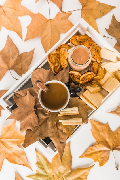 Foglie intorno alla scatola con cibo per la colazione