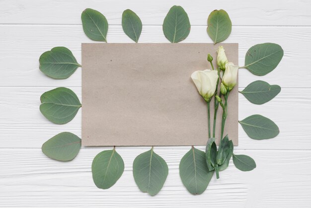 Leaves around paper and flowers