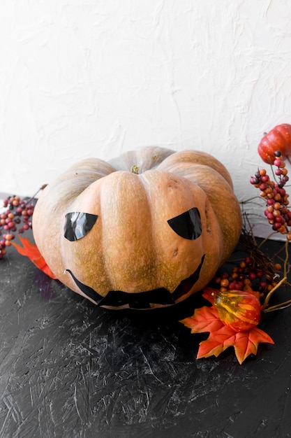 Leaves and berries near scary jack-o-lantern