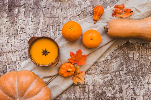 Листья и апельсиновые фрукты возле супа