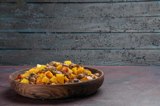 Left side view friedpotatoes with mashrooms mushrooms with potatoes in a bowl on the dark background