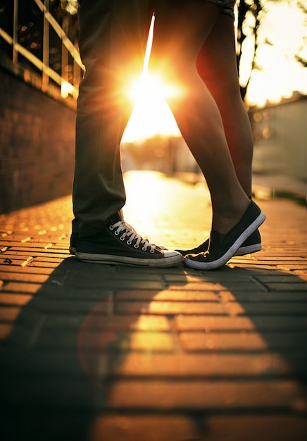 Legs close-up of loving couple at sunset