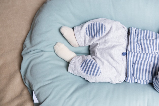 Foto gratuita gambe e piedi del bambino sdraiato sul morbido materasso blu