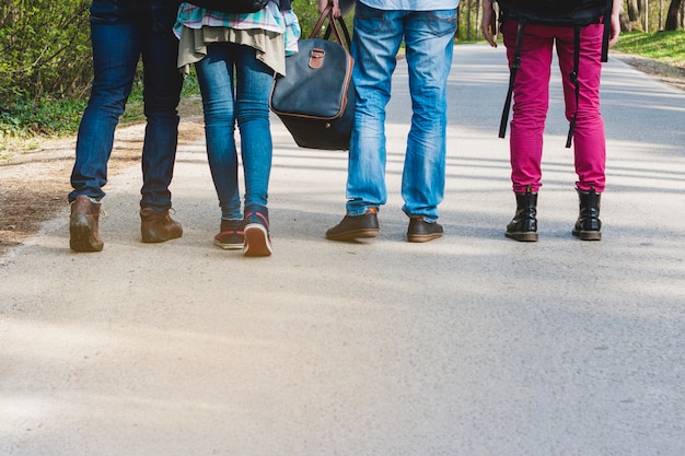 Gambe di quattro turisti che camminano