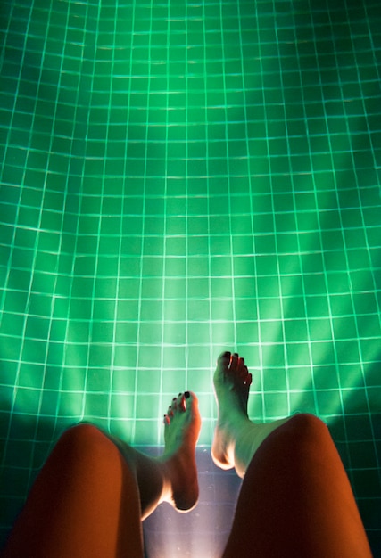 Free photo legs hanging pool light glowing