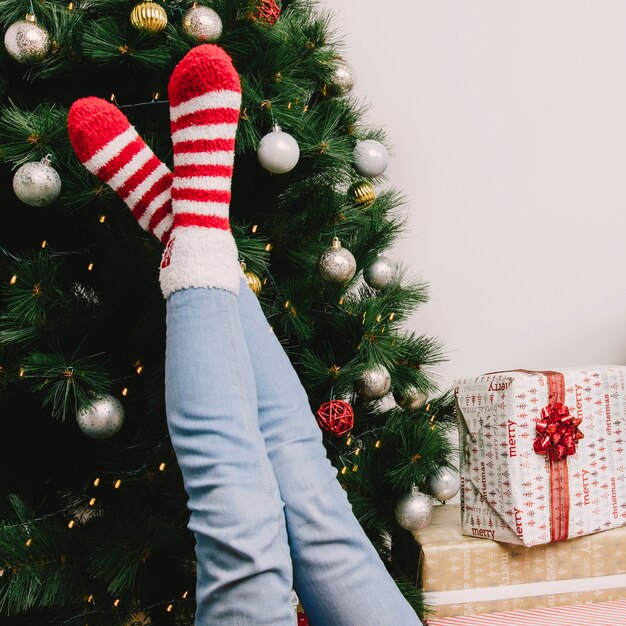 Legs of woman in front of christmas tree