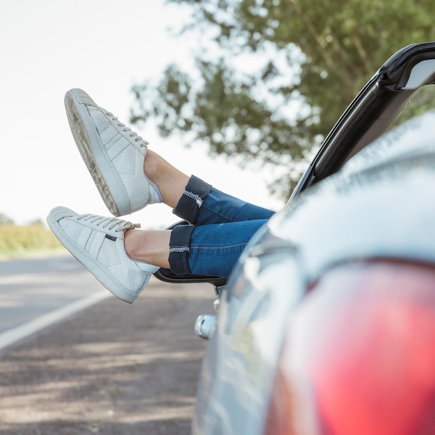 Legs of woman hanging out of car