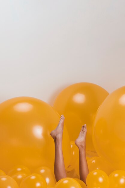 Legs of woman between many yellow balloons