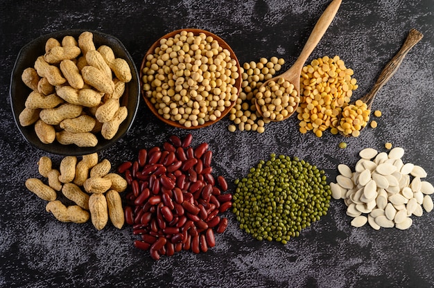 Legumes, and beans assortment on the black cement floor.