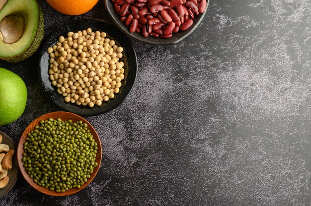 Legumes and fruits on black cement floors.