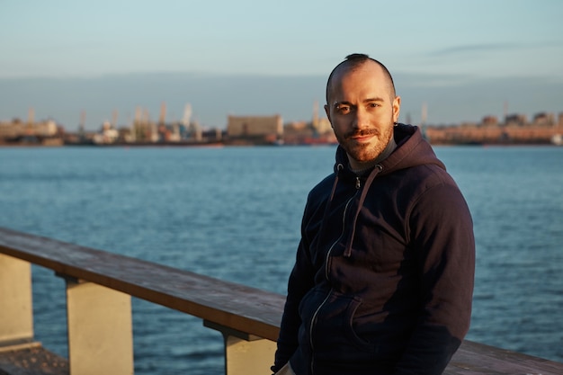 Tempo libero, attività, persone e concetto di città. foto di giovane uomo con la barba lunga gioiosa bello in nero