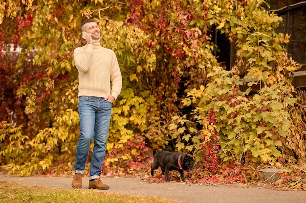 Leisure. A young man in beige turtleneck talking on the phone