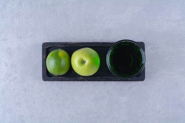 レモン、リンゴ、リンゴジュースを木の板に、大理石のテーブルに。