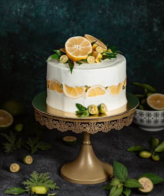 Lemon cake decorated with white cream and citrus fruits