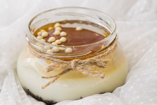 Lemon curd with chocolate in jar on lace textile