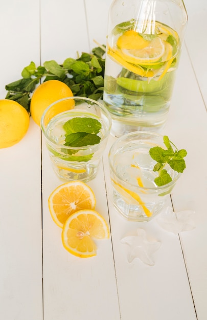 Foto gratuita bevanda al limone in bottiglia e bicchieri