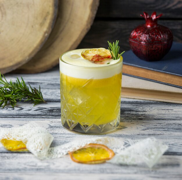 Lemon drink garnished with dried lemon slice, rosemarine in crystal glass