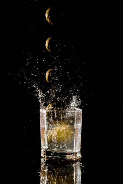 Lemon falling into a glass