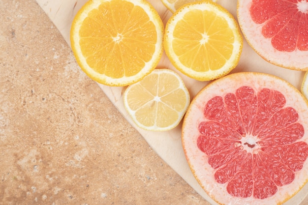 Lemon and grapefruit slices on marble surface.
