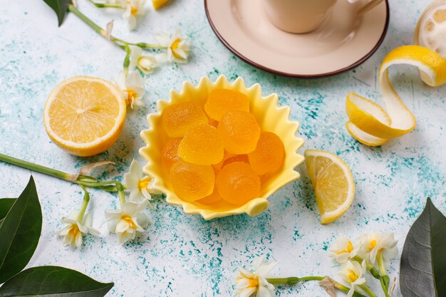 Lemon jelly candies with fresh lemons ,top view