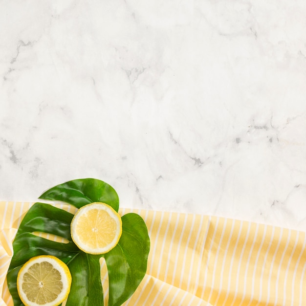 Free photo lemon on monstera leaf with copy space