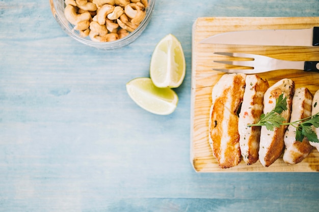 Lemon near cut meat on wooden board