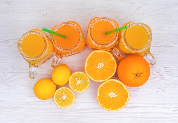 Вид сверху лимон и апельсиновый сок на поверхности