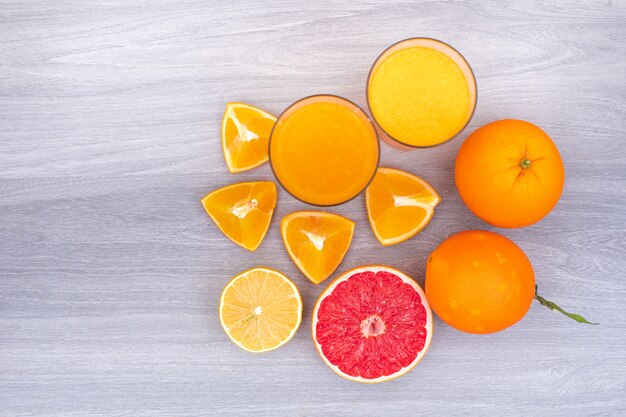 Lemon and orange juice top view on white  wooden table