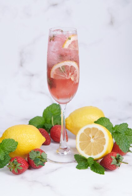 Lemon and strawberry lemonade mint fresh homemade in glass, Summer cold cocktail, Strawberry lemon lime mojito, light background, copy space, A refreshing summer drink concept.