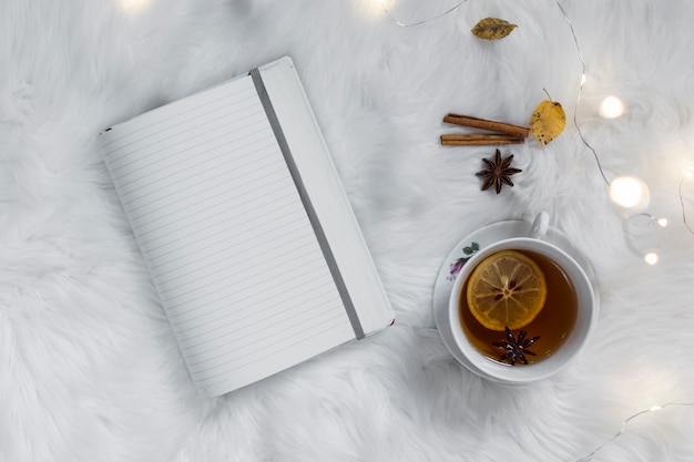 Lemon tea with notebook on fluffy white plaid