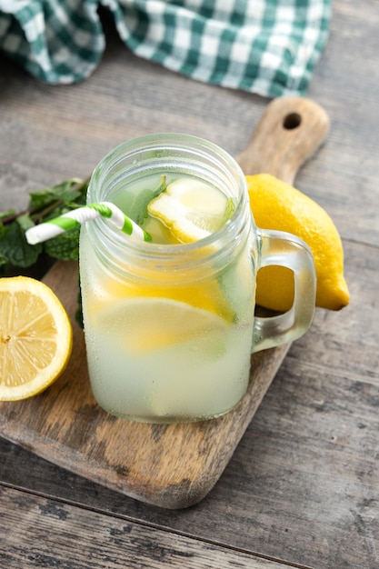 Lemonade drink in a jar glass and ingredients on wooden table