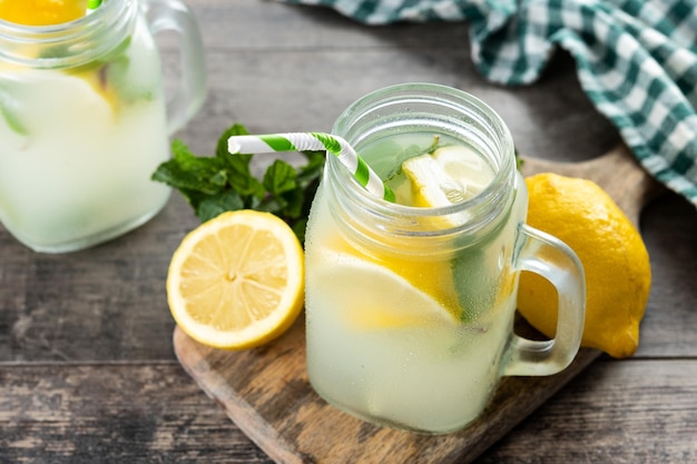 Lemonade drink in a jar glass and ingredients on wooden table