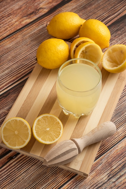 Lemonade in a glass cup on the wooden board, top view