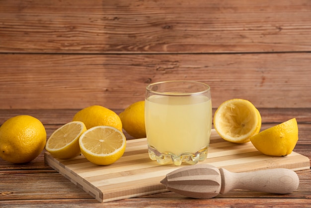 Lemonade in a glass cup on the wooden board