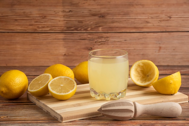 Free photo lemonade in a glass cup on the wooden board