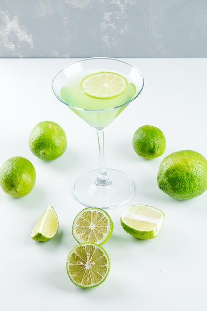 Lemonade in a glass with lemon high angle view on white and plaster