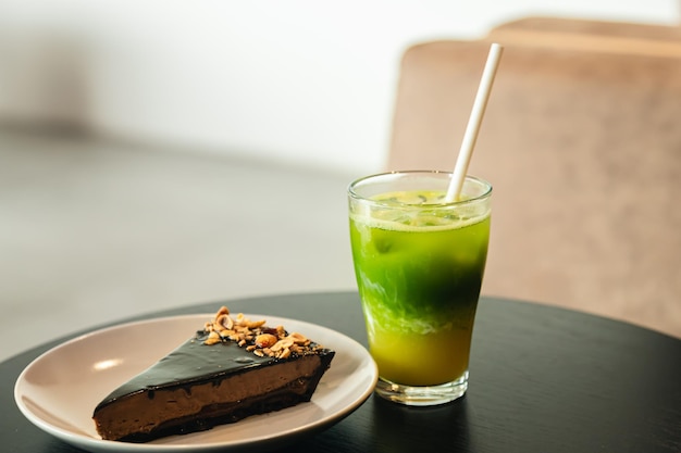 Free photo lemonade and a piece of chocolate cake on a table in a cafe interior