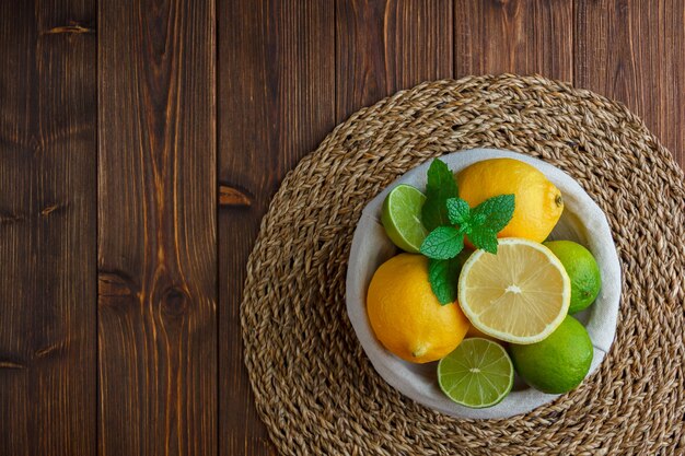 Lemons in a basket on a wooden surface. top view.