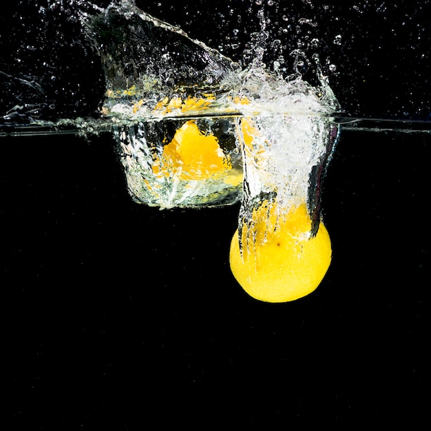 Lemons falling into water splash