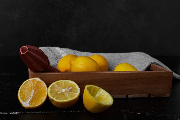 Lemons isolated in a wooden tray.