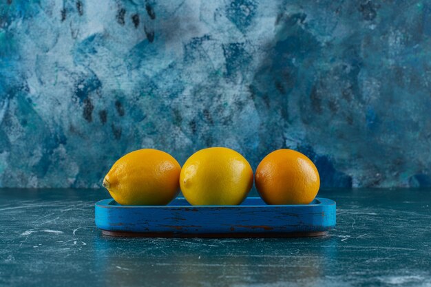 대리석 테이블에 나무 접시에 레몬.