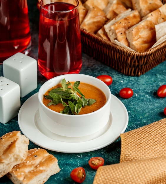 Free photo lentil soup in a white bowl and a glass of compote