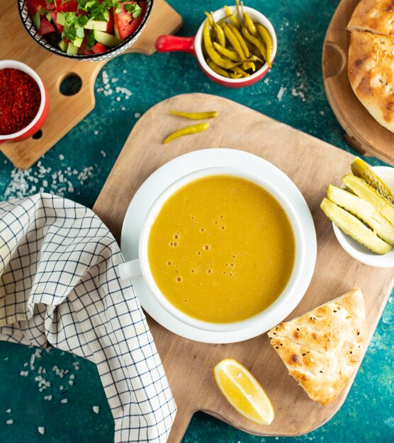 Lentil soup with bread on wooden board