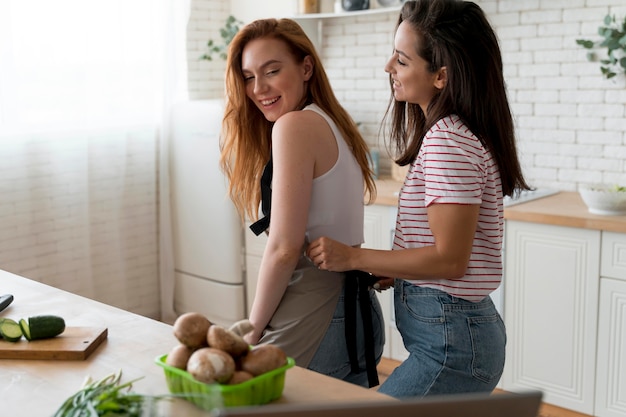 Lesbian couple being affectionate in the kitchen